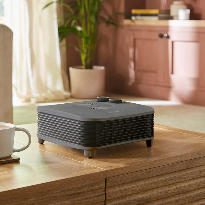 Black heater on a wooden surface with a blurred kitchen background