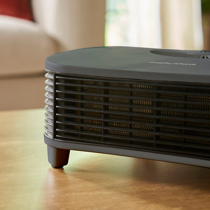 Black heater on a wooden surface with a blurred background