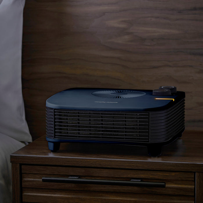 Black heater on a wooden nightstand with a blurred background