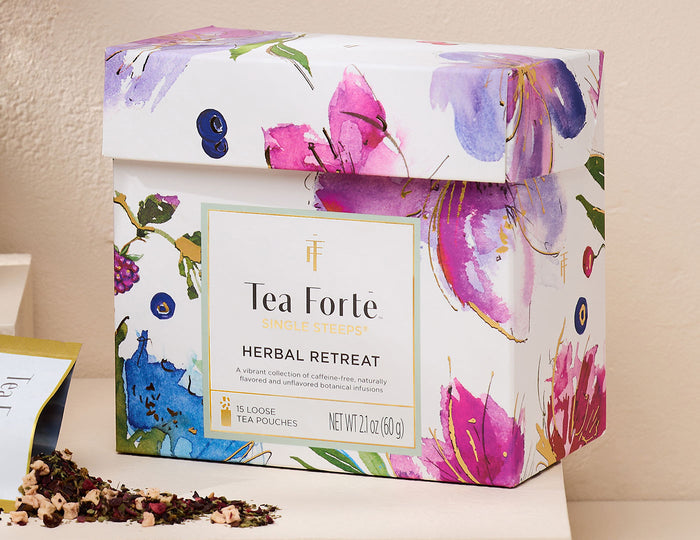 Herbal Retreat Single Steeps Sampler  box, closed with a loose tea pouch open and pouring out tea