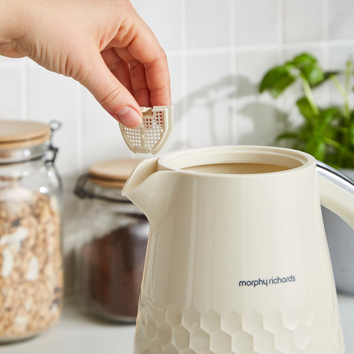Person placing a filter into a Morphy Richards kettle on a kitchen counter.