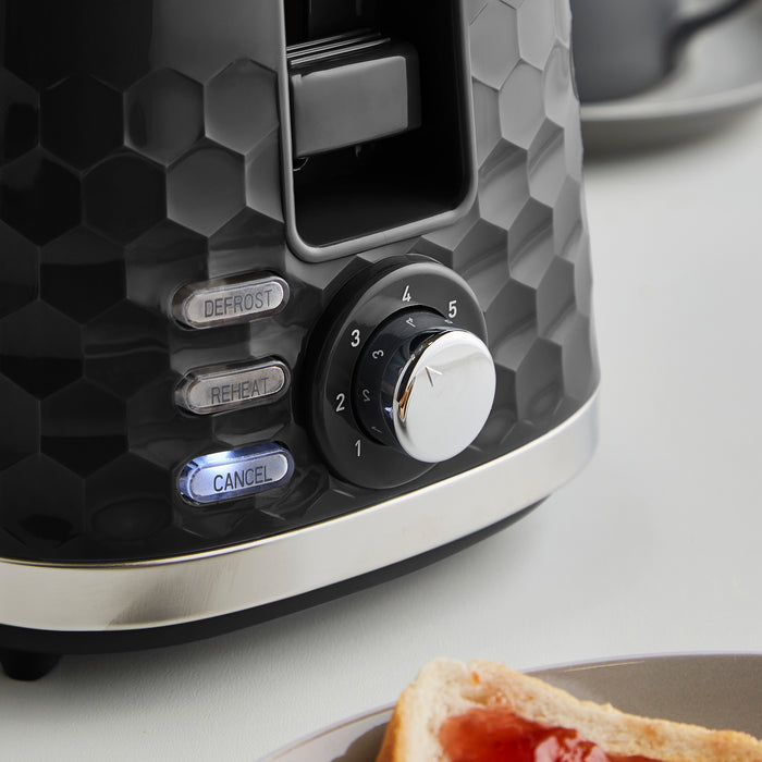 Close-up of a toaster with control knobs on a light background