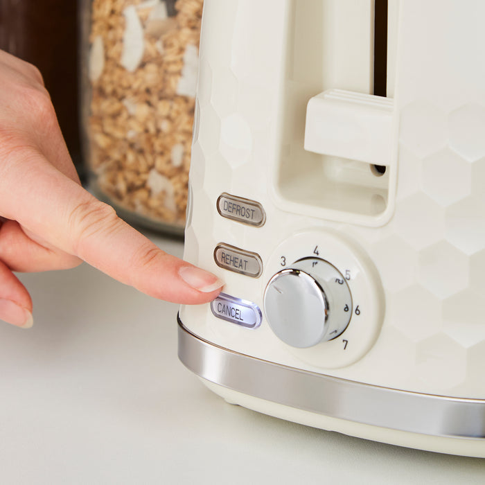 Person pressing a button on a cream toaster with cereal in the background