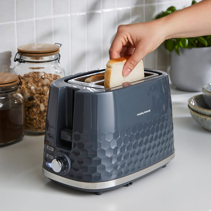 Person placing toast into a blue toaster on a kitchen counter.