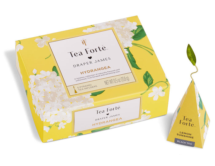 Yellow presentation box containing Tea Forte Hydrangea tea pyramids with white flower and green leaf pattern design.