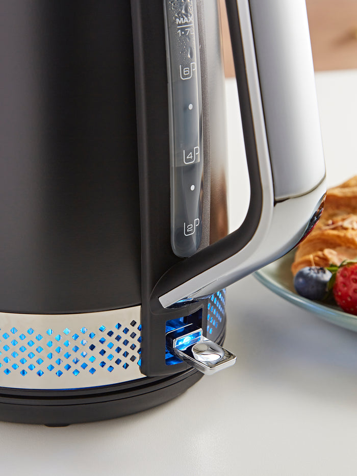 Black electric kettle with blue LED lights on a white surface
