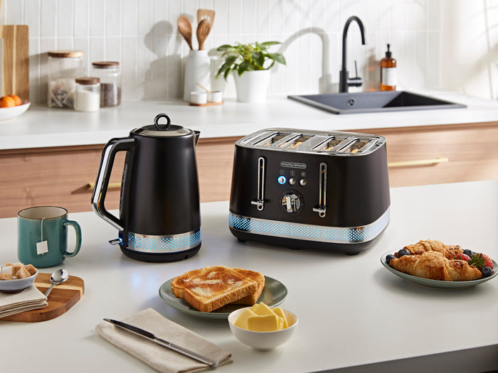 Black toaster and kettle on a kitchen counter with breakfast items.