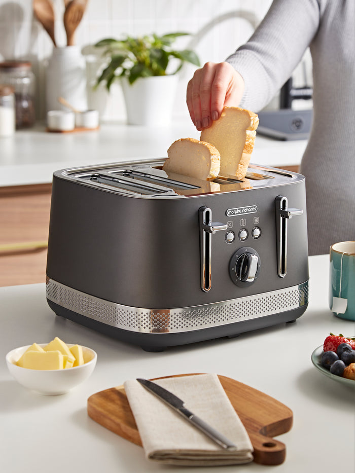 Person placing bread into a black toaster on a kitchen counter.