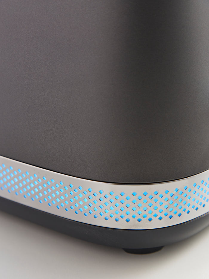 Close-up of a black Toaster with a blue LED strip on a light gray background