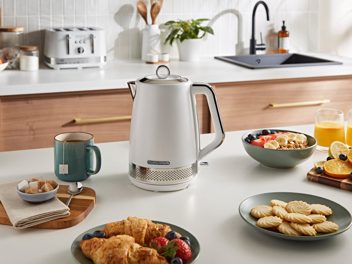 White electric kettle on a kitchen counter with breakfast items