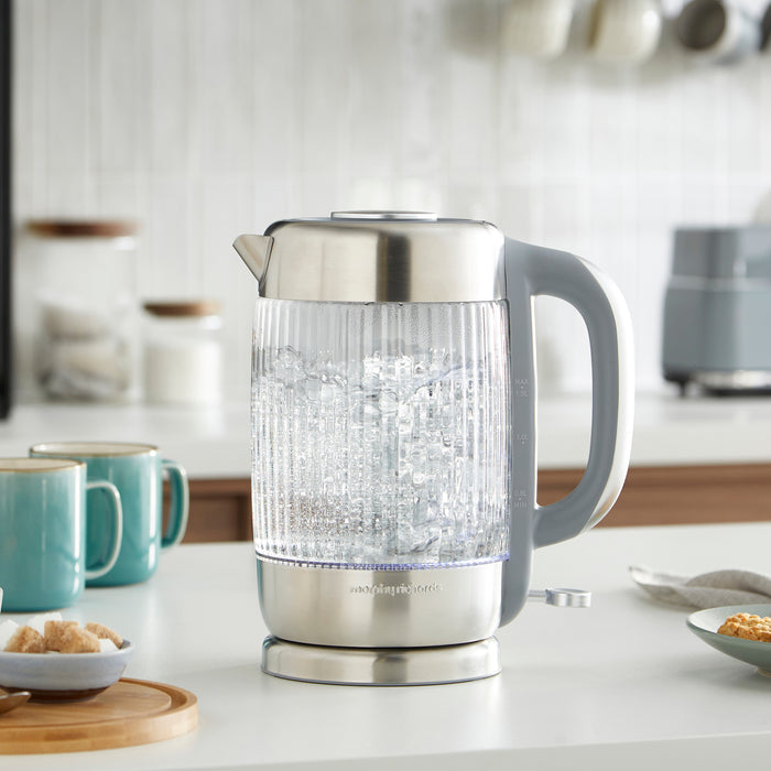 Clear glass electric kettle on a kitchen counter with blurred background