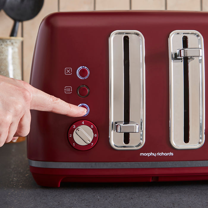 Red toaster with silver accents being operated by a hand, featuring the Morphy Richards brand.