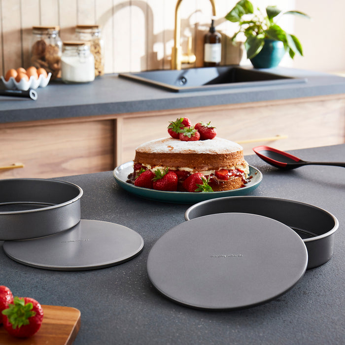 Kitchen counter with cake, pans, and kitchen items