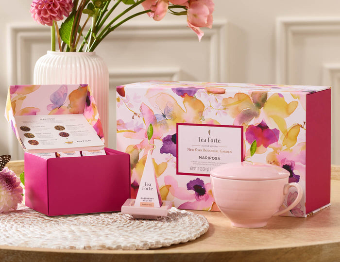 MAIN PDP | Mariposa Gift Set on a table, of 10 pyramid tea infusers, one Tea Tray and one Rose Pink Café Cup
