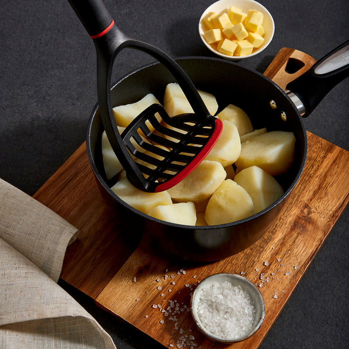 Masher mashing roast potatoes