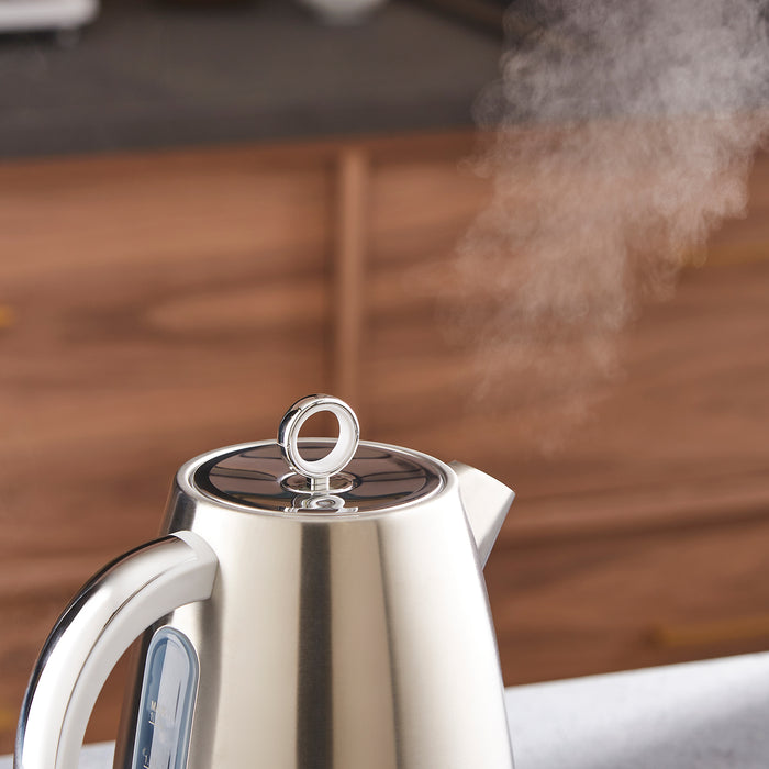 Silver electric kettle with steam rising from it on a wooden surface