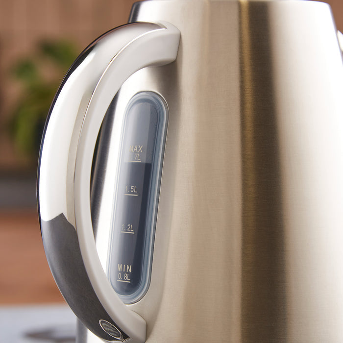 Close-up of a silver electric kettle with measurement markings on a blurred background