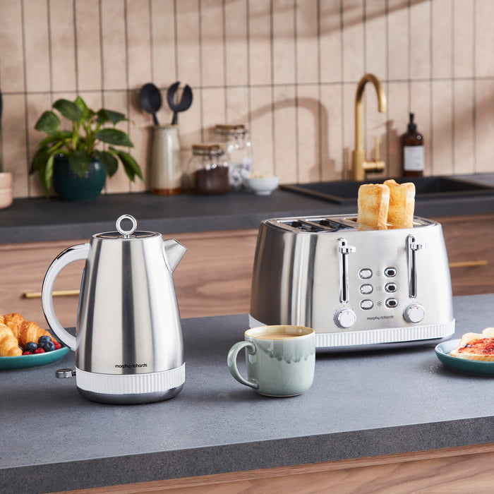 Kitchen counter with a kettle, toaster, and mug in a home setting.