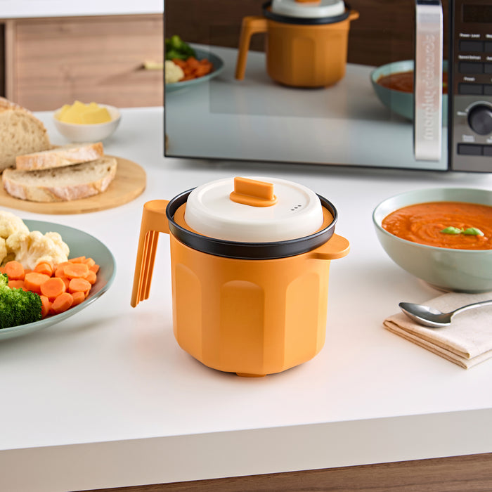 Microwave Saucepan on the kitchen side next to a bowl of soup and a plate of vegetables