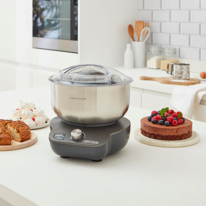 Kitchen food mixer on a kitchen counter with desserts around