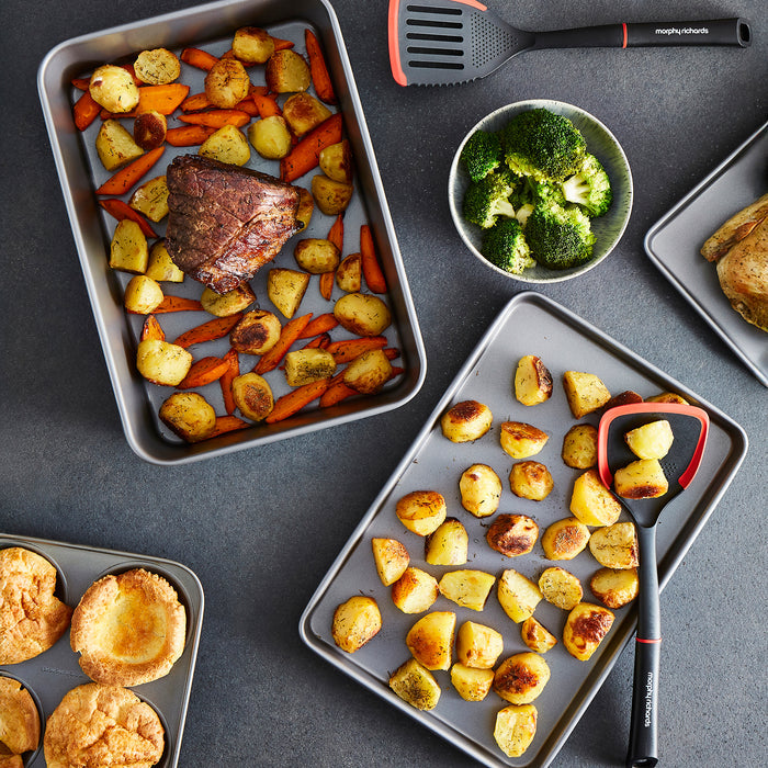 Roast beef with carrots and roasted potatoes in a roasting tin