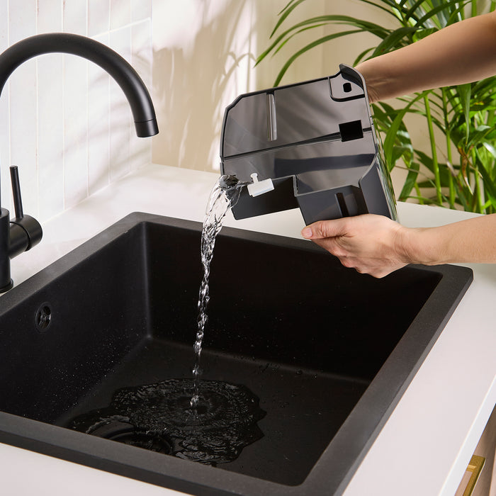 Person holding a Morphy Richards dehumidifier water tank