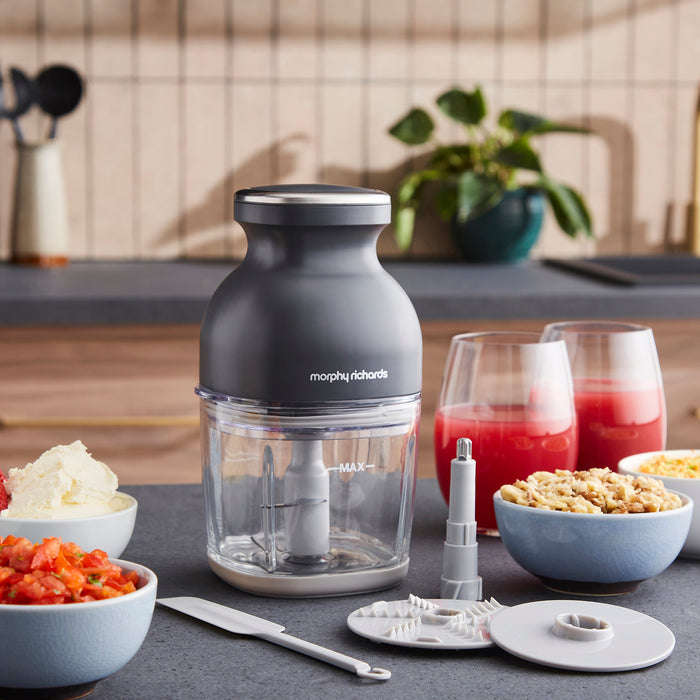Morphy Richards mini chopper on a kitchen counter with ingredients and drinks in the background