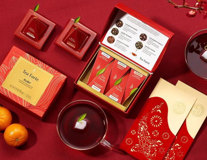MAIN PDP | Ruby MIni Petite Box on a dark red background with Lunar New Year chocolate and oranges.
