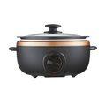 An oval-shaped black and bronze Morphy Richards Sear & Stew Slow Cooker with a glass lid.