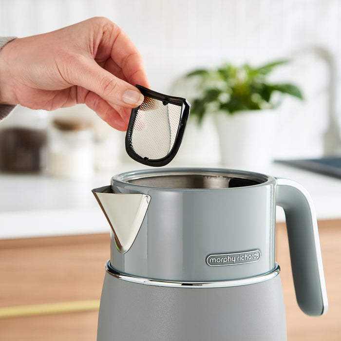 Person removing the filter from a grey kettle