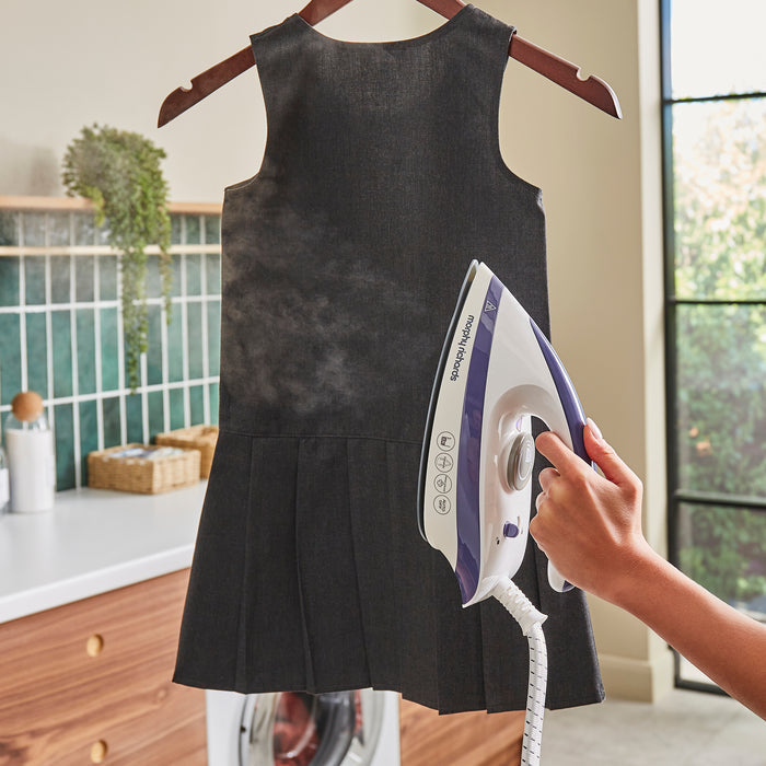 lady ironing school dress with steam iron