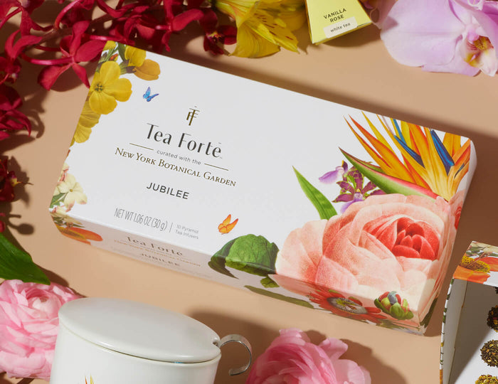 MAIN PDP | Jubilee Presentation Box of 20 pyramid teas, lid closed, on a table of flowers and teas