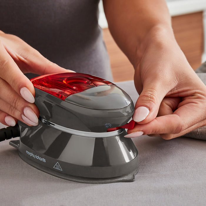 person choosing setting on travel iron