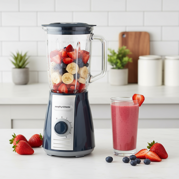 Blender with fruits and a smoothie on a kitchen counter