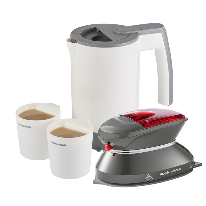 A travel iron and travel kettle set with a white kettle, grey iron, and two white cups filled with a liquid, all designed for travel use.