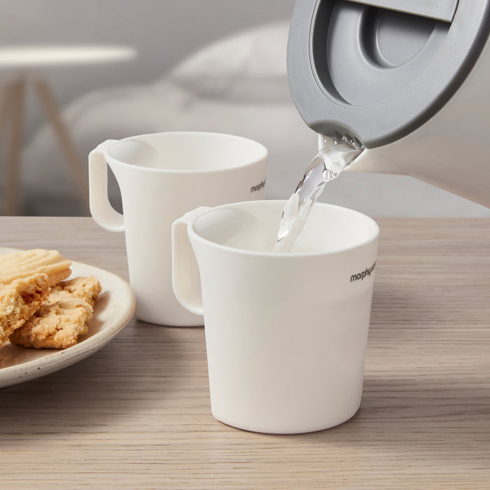 water pouring into small cup from travel kettle