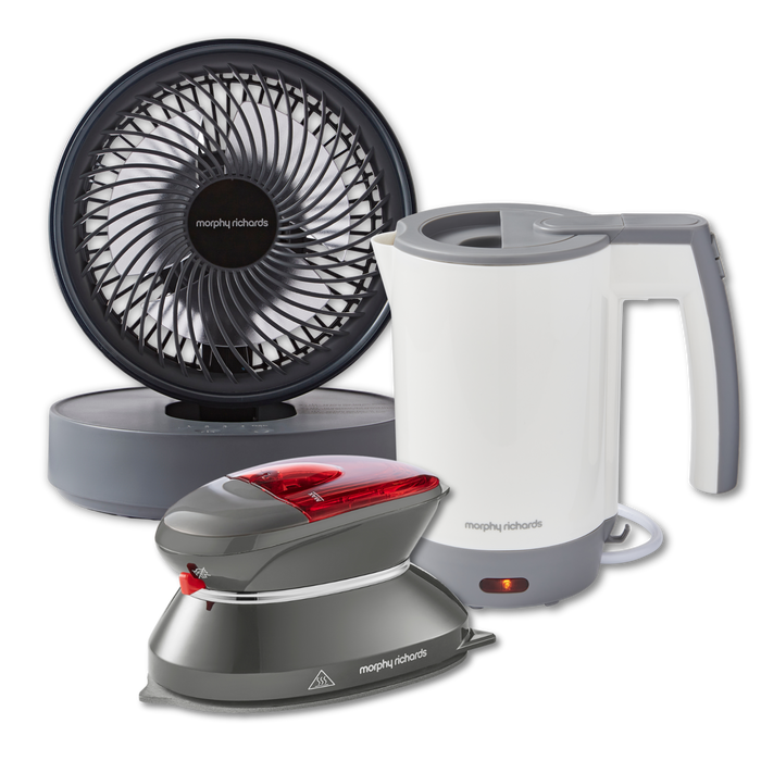 A set of three portable travel appliances including a black and white electric kettle, a grey and red portable steam iron, and a black oscillating USB fan.