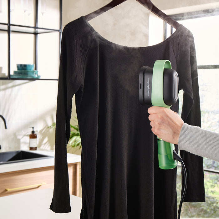 Handheld garment steamer, steaming a black top
