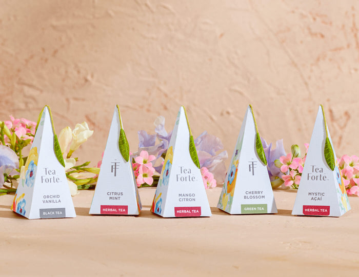 Volare pyramid tea infusers, one of each blend on a tan background with flowers