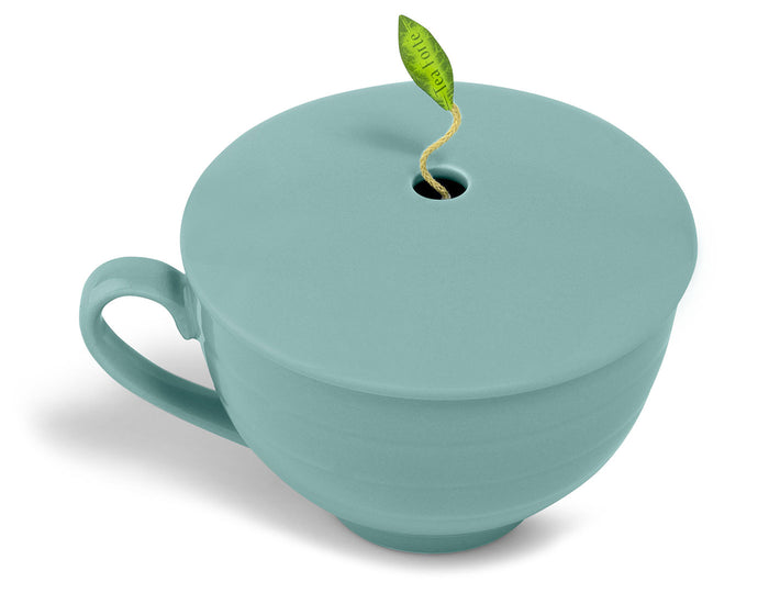 Teal ceramic cup with lid and green leaf-shaped handle accent on white background.