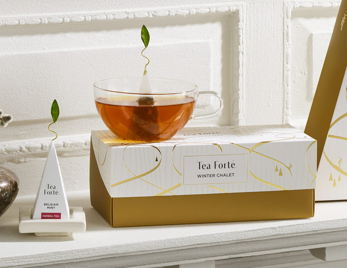 MAIN PDP | Presentation Box of Winter Chalet, closed, with a glass teacup and white tea tray